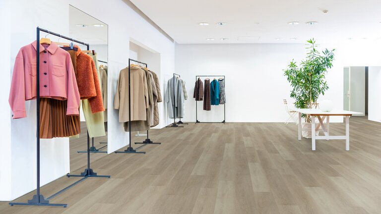 Modegeschäft mit Kleidungsständern und Holzfußboden.